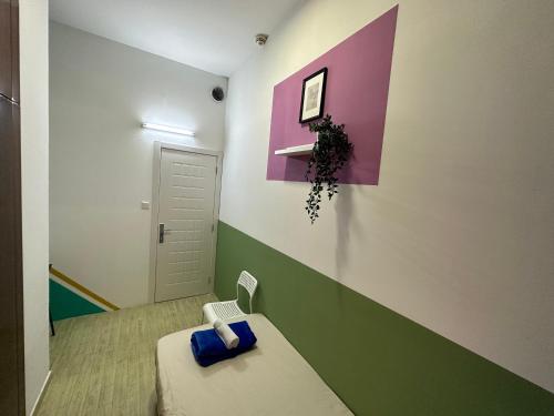 Kleines Zimmer mit einem Bett und einer lila und grünen Wand in der Unterkunft Spacious Mini Partition Room Near Emirates Mall in Dubai
