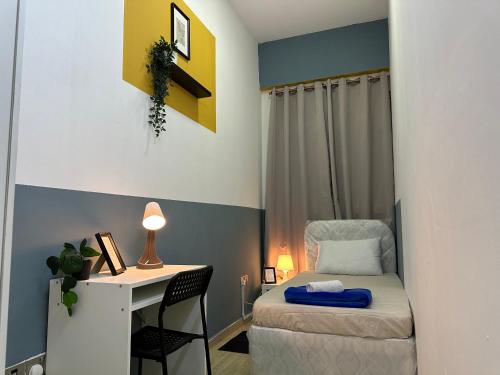 Habitación pequeña con escritorio y cama en Spacious Mini Partition Room Near Emirates Mall, en Dubái