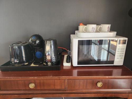 a microwave sitting on top of a wooden table at Blueberry Hill Vineyard Stay in Rothbury