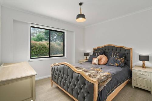 Un dormitorio con una cama grande y una ventana en Silverhill Cottage, en Exeter