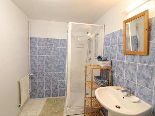 a blue tiled bathroom with a sink and a mirror at Gîte Murat-Chastel-sur-Murat, 2 pièces, 4 personnes - FR-1-742-48 in Murat