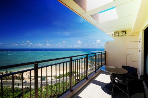 a balcony with a view of the ocean at Kafuu Resort Fuchaku Condo Hotel in Onna