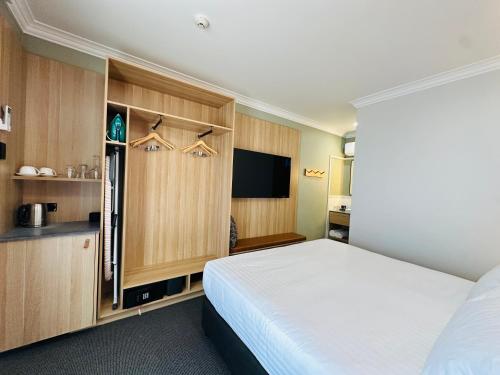 um quarto com uma cama e uma televisão de ecrã plano em Royal Hotel-Motel em Moree