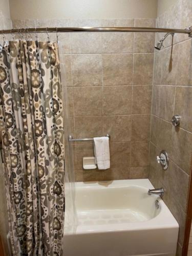 La salle de bains est pourvue d'une baignoire et d'une douche avec rideau de douche. dans l'établissement Morning Star Lodge - Hosted by Linda, à Kellogg