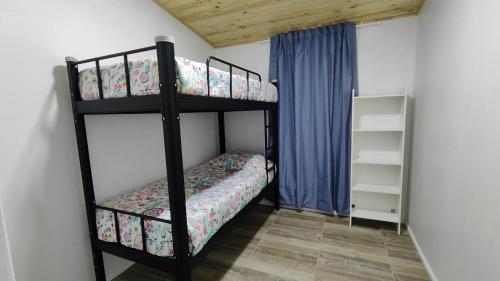 1 dormitorio con 2 literas en una habitación en Cabaña 4-6 personas con piscina, en Algarrobo