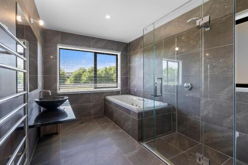 Das Bad ist mit einer Badewanne und einer Glasdusche ausgestattet. in der Unterkunft Meadowscape Hideaway - Martinborough Holiday Home in Martinborough 