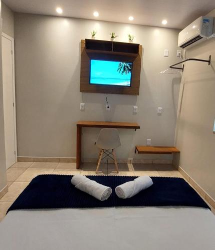a room with a television and two pillows on the floor at Suite Praia Parque in Penha