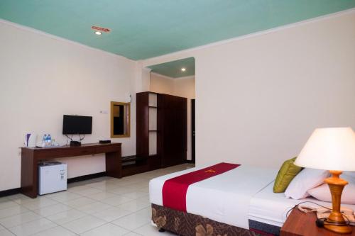 a hotel room with a bed and a television at UrbanView Hotel Anggraeni Jatibarang in Jatibarang