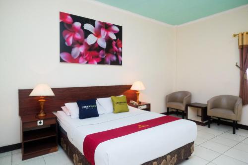 a hotel room with a bed and two chairs at UrbanView Hotel Anggraeni Jatibarang in Jatibarang