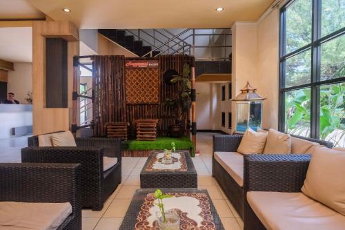 a living room with couches and a table at UrbanView Hotel Anggraeni Jatibarang in Jatibarang