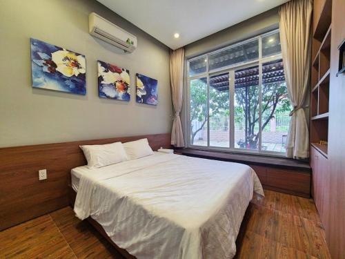 カンザーにあるCần Giờ Homestayのベッドルーム(白いベッド1台、窓付)
