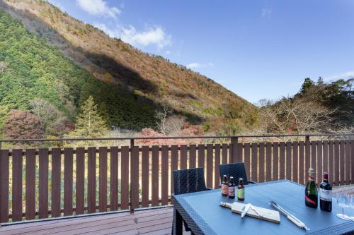 a blue table with wine bottles on a wooden deck at SMART VILLA Hakone Sukumogawa Riverside in Hakone