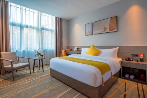a hotel room with a bed and a desk and a chair at Luzhou Baian Smart Hotel in Luzhou