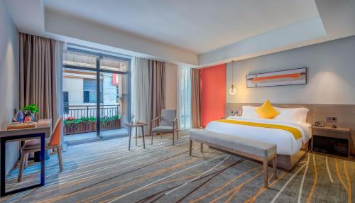 a hotel room with a bed and a balcony at Luzhou Baian Smart Hotel in Luzhou