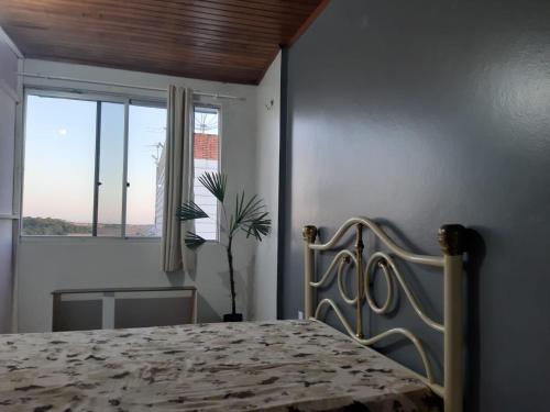 a bedroom with a bed and a large window at Casa Winter - Seu Quarto Ideal in Santa Rosa