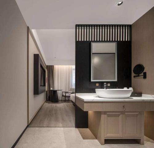ein Badezimmer mit einem Waschbecken und einem großen Spiegel in der Unterkunft MSW Hotel Changzhou in Changzhou