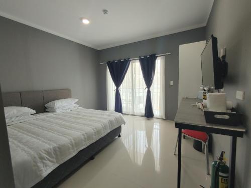 1 dormitorio con cama, escritorio y ventana en CASABLU HOTEL&RESORT en Maribago