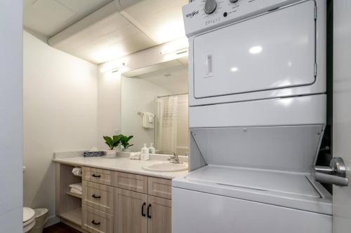 a bathroom with a sink and a white refrigerator at Modern Country Retreat-5 min to DTN-U/G Parking in Edmonton