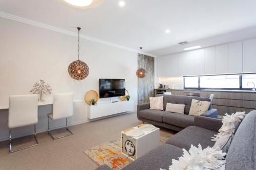 a living room with a couch and a table at Bambino 438 in Perth