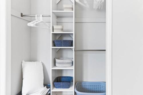 a closet with white shelves and blue baskets at The Cranbrook- Close to OSU-Downtown Columbus-Short North-Clintonville-Upper Arlington in Columbus