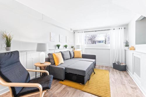 a living room with a gray couch and chairs at The Cranbrook- Close to OSU-Downtown Columbus-Short North-Clintonville-Upper Arlington in Columbus