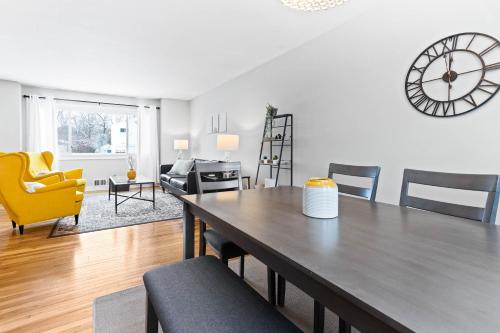 a dining room and living room with a table and a clock at The Cranbrook- Close to OSU-Downtown Columbus-Short North-Clintonville-Upper Arlington in Columbus