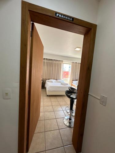 a room with a door open to a bedroom with a bed at Suites Centro Torres in Torres