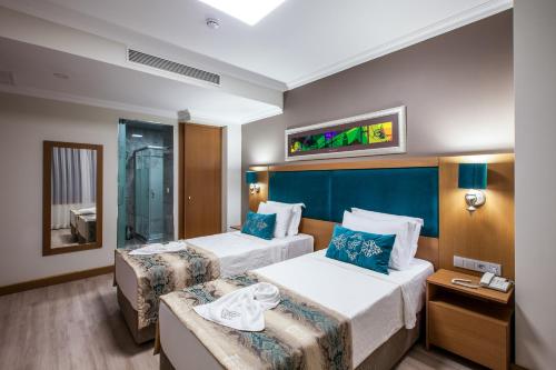 a hotel room with two beds and a mirror at Ferman Hilal Hotel-Special Category in Istanbul