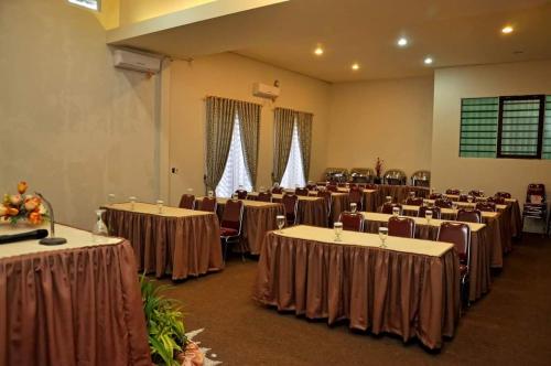 パダンにあるSurya Palace Syariahのテーブルと椅子が並ぶ部屋