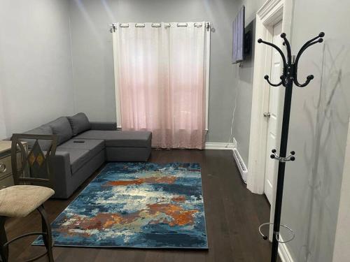 een woonkamer met een bank en een tapijt bij Downtown apartment 2/3 people . in Bowmanville