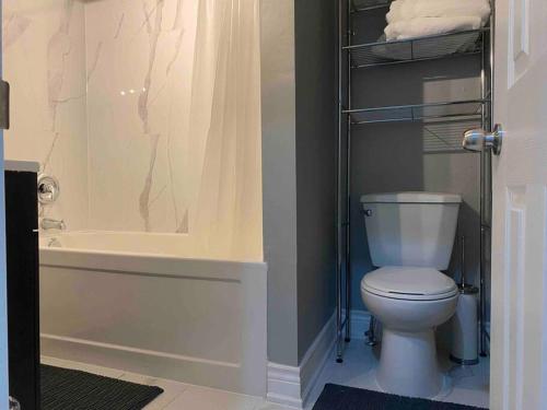 a bathroom with a white toilet and a shower at Downtown apartment 2/3 people . in Bowmanville