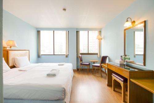 um quarto de hotel com uma cama, uma secretária e um espelho em Wish Inn Ratchaprasong - Chidlom วิช อินน์ ราชประสงค์ ชิดลม em Makkasan