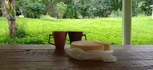 a table with a piece of bread and a pair of boots at Canastra Hostel e Camping - quartos in Vargem Bonita