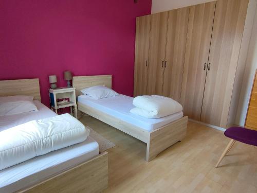 - une chambre avec 2 lits et un mur violet dans l'établissement Maison Familiale de Charme à 300m de la Plage - Saint Jean de Monts, 6 Pers, Wifi Gratuit - FR-1-323-408, à Saint-Jean-de-Monts