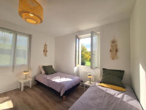 a bedroom with two beds and a window at Charmant Gîte Cocooning avec Terrasse et Animaux Acceptés - FR-1-496-306 in Belmont-de-la-Loire