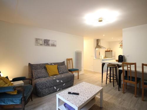 un salon avec un canapé et une table dans l'établissement Bel Appartement T3 Rénové avec Wi-Fi à 400m des Thermes de La Bourboule, Capacité 4 Personnes - FR-1-608-261, à La Bourboule