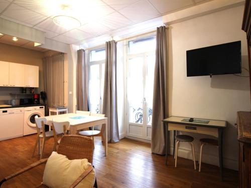 un salon avec une table et une cuisine dans l'établissement Confortable T3 avec Wi-Fi à 200m des thermes - 5 couchages max - FR-1-608-260, à La Bourboule