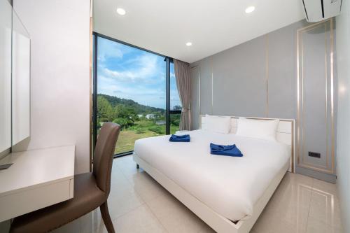 a white bed in a room with a window at 1BR Condo, Hill View Viva Patong C301, Freedom Beach in Patong Beach