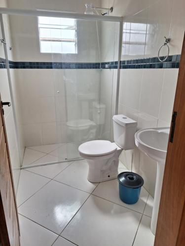 ein weißes Badezimmer mit Toilette und Waschbecken in der Unterkunft Casa para temporada em caraguatatuba praia do Massaguaçu in Caraguatatuba