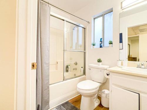 La salle de bains blanche est pourvue de toilettes et d'un lavabo. dans l'établissement 1 Bedroom Hollywood Habitat - BR11, à Los Angeles