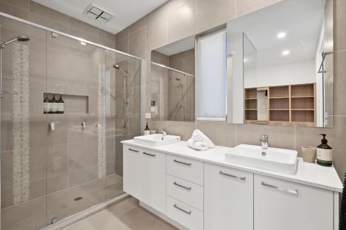 a bathroom with two sinks and a shower at Bella Beach Resort - An Oasis on the Bellarine with heated pool in Saint Leonards