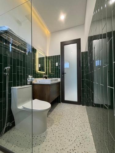 y baño con aseo, lavabo y ducha. en RiWin Hotel Pleiku en Plei Brêng