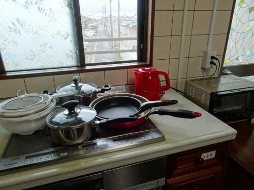 blat kuchenny z garnkami i patelniami na kuchence w obiekcie Corpo Umeyama 2F / Vacation STAY 3912 w mieście Mibu