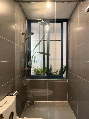 a bathroom with a shower and a toilet and a window at MOONLIGHT Homestay & Hotel in Pleiku