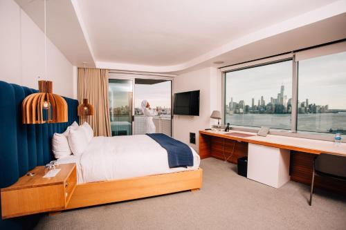 a hotel room with a bed and a desk and a window at W Hoboken in Hoboken