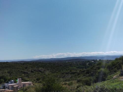 uma vista para as montanhas a partir do topo de uma colina em El Roble, casa de sierra em Estancia Vieja