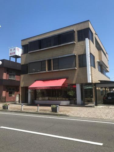 a building with a red awning on the side of a street at Corpo Umeyama 2F / Vacation STAY 4853 in Mibu