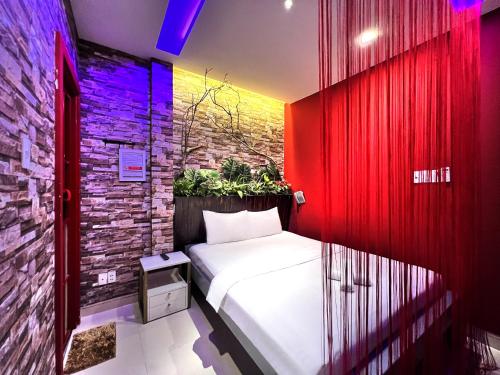 a bedroom with a bed and a brick wall at Loove Hotel - Khách Sạn Tình Yêu in Ho Chi Minh City
