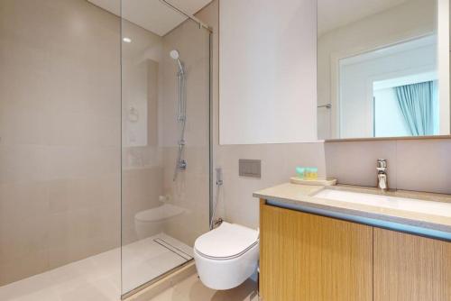 a bathroom with a toilet and a sink and a shower at Summer at Creek Beach - Vacationer in Dubai