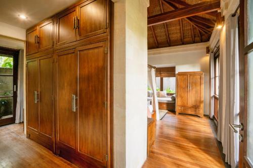 a hallway with wooden cabinets in a house at Villa Pulung Jimbaran by Nakula in Jimbaran